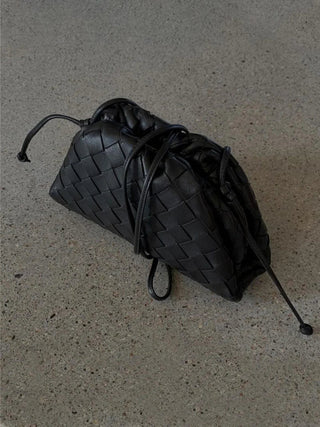 Gevlochten tas met trekkoord van imitatieleer, geschikt voor dagelijks gebruik en avondgelegenheden, die stijl en functionaliteit combineert.